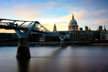 View of the famous St. Pauls Cathedral across the river Thames with Millennium Bridge at sunset