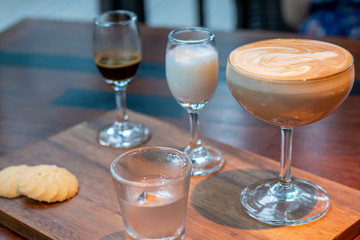 Cappuccino is an espresso-based coffee drink. Latte art at cafe. White Cup of art latte on a cappuccino coffee. Cappuccino with smiley frothy foam, coffee cup top view close up.