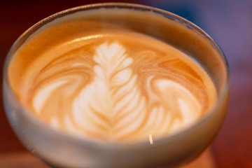 Selected focus, cups of cappuccino with latte art on wooden table background. Cup of coffee latte art in coffee shop. Cup of coffee with beautiful Latte art.