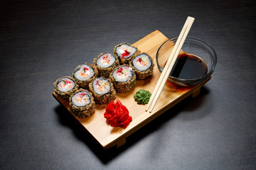 Tasty and delicious hot and cold sushi rolls on the table. Different sushi - rolls with sauce on the board of Japanese cuisine.