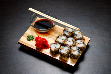 Tasty and delicious hot and cold sushi rolls on the table. Different sushi - rolls with sauce on the board of Japanese cuisine.