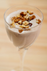 Top view of ice cream smoothie with banana and nuts sprinkled with chocolate