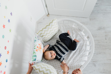 A newborn boy is lying in his crib. © Oksana