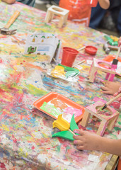 Fototapeta premium Kid hands painting craft at building workshop in local hardware store in Texas, USA