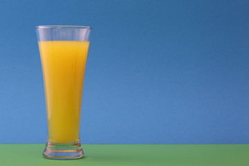 Glass of orange juice  on a blue background
