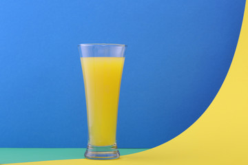 Glass of orange juice  on a blue background