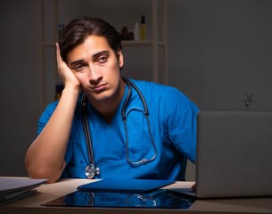 Young handsome doctor working night shift in hospital