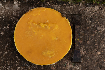 A large piece of yellow wax and beekeeper tools. Bees are flying. Home apiary. Flat lay