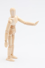 Wooden dummy refusing something to someone in front of a white background