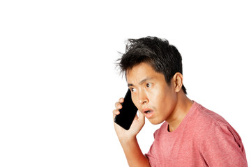Young man talking on the phone, shocked with and surprise face on white background.