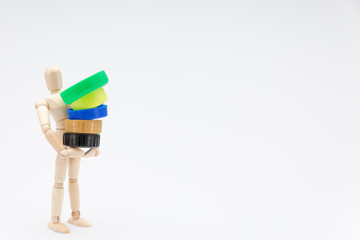Wooden dummy carrying plastic plugs in front of a white background