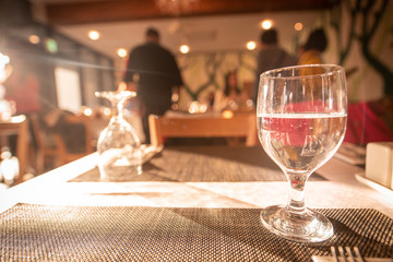 Glass of water on luxury table setting for dining. Selective focus. Warm tone.