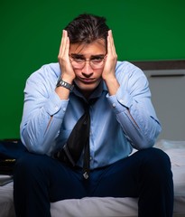 Young businessman under stress in the bedroom at night