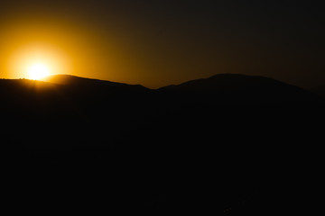 mountain silhoette of austrian alps at sunrise glowing sky