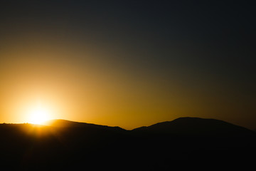 mountain silhoette of austrian alps at sunrise glowing sky