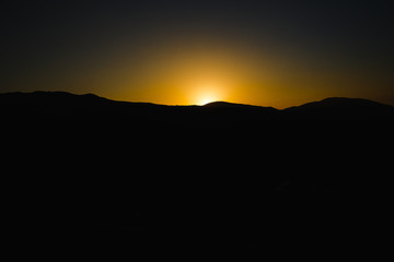mountain silhoette of austrian alps at sunrise glowing sky