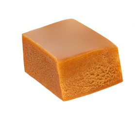 Homemade caramel piece isolated on white background. Golden Butterscotch toffee candy caramel macro.