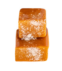 Caramel candies and sweet sauce isolated on white background, top view. Homemade salted caramel pieces