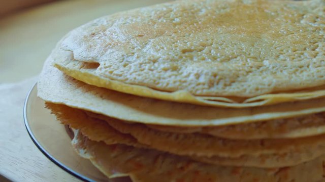 Yummy yellow pancake stack on glass plate. Home cooking steam. Slowmo closeup.