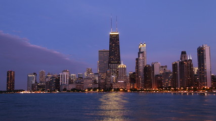 Chicago city urban skyscraper with John Hancock Center at night at downtown lakefront illuminated with Lake Michigan viewed from North Avenue Beach