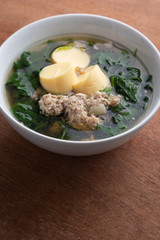 Boiled minced pork and tofu soup with gourd in white bowl on wooden table, Thai food, Healthy food.