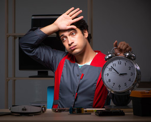 Young handsome repairman repairing computer