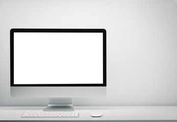 Blank screen computer display for mockup in office interior, Work desk with keyboard, mouse. Copy space on wall for text.