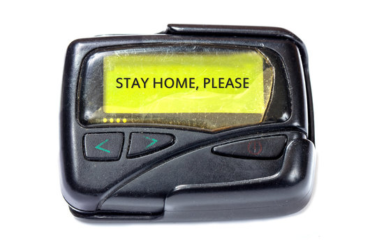 Old pager on white background. Message on the screen: Stay home, please
