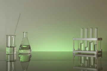 conceptual background with chemical flasks and lab glassware. lab glassware on glass table