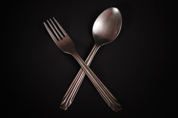 fork and spoon on black