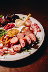 Stock Photo - Meat plate: 
sausage, bacon, savory appetizers and sauces