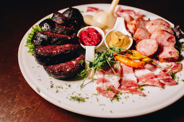 Stock Photo - Meat plate: 
sausage, bacon, savory appetizers and sauces
