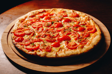 Stock Photo - Fresh delicious Italian pizza  on a dark background