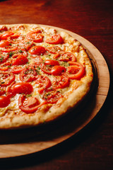 Stock Photo - Fresh delicious Italian pizza  on a dark background