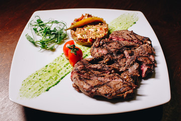 Stock Photo - Ribeye steak with vegetable dressing on a white plate