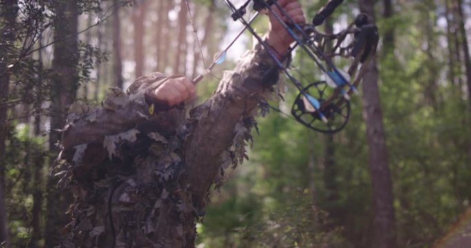 Man bow hunting in woods