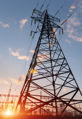High-voltage power lines at sunset or sunrise. High voltage electric transmission tower