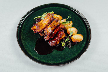 Fresh and delicious grilled pork ribs with fried potatoes on table