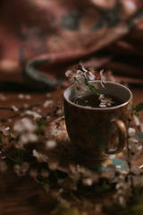 Cup of tea with blooming flowers