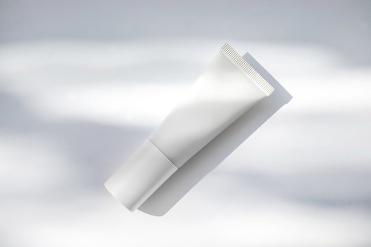 Mockup de frasco de crema hidratante blanco con sombras naturales