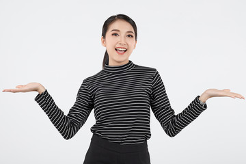 Beautiful young asian business woman in smart casual wear having showing empty hand and smile isolated on white background. Proposing product, advertisement, emotions, gestures.