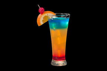 Rainbow cocktail with ice, orange, and a cherry on black background.