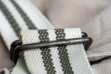 Long cloth belt with a metal buckle on a pants, closeup