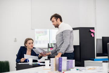 A male office employee showing something to his senior colleague hoping to receive an advice