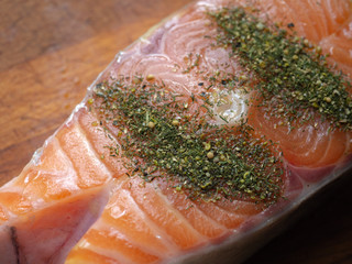 raw salmon Steak with spices on a wooden Board