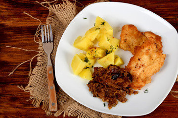 fried cabbage with dried mushrooms, boiled potatoes with dill and breaded pork tenderloin