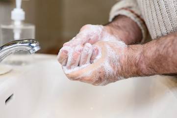 Close up of Senior man washing his hands using soap foam, Prevention from covid19, Coronavirus or Bacteria. Healthcare concept, 7 step hands wash .