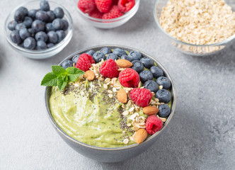 Healthy breakfast bowl: smoothie with banana, raspberry, avocado, blueberry,  almonds, chia seeds and mint. Raw, vegan, vegetarian food concept.