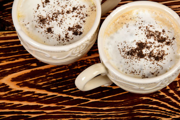 cups with coffee and milk foam sprinkled with dark chocolate