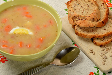 white sour soup with sausage, egg and bread